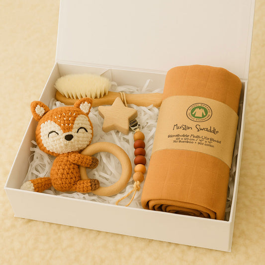 Baby gift set with fox rattle, brush, and swaddle blanket in a box.