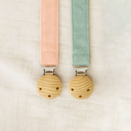 Two dummy catchers in pink and green on a beige background